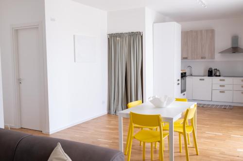 a living room with a white table and yellow chairs at FP Apartments Pizzo in Pizzo