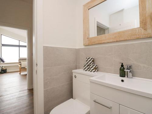 a bathroom with a sink and a mirror at Driftwood Cottage in Ulverston