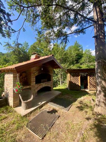 a small brick oven in a yard with a tree at Vila Dolina Izvora in Sarajevo