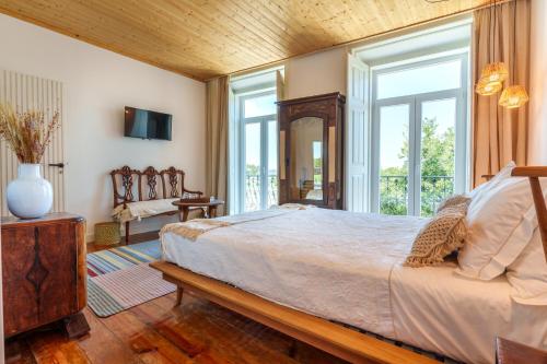 a bedroom with a large bed and a large window at Villa Sado in Alcácer do Sal