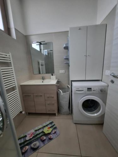 a bathroom with a washing machine and a sink at La Rosa di Emma in Porlezza