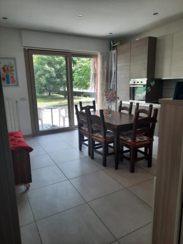 a kitchen with a dining room table and chairs at La Rosa di Emma in Porlezza