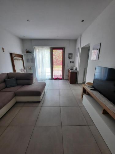 a living room with a couch and a television at La Rosa di Emma in Porlezza