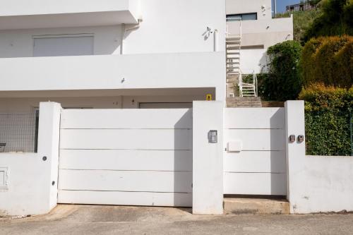 a white garage door in front of a white house at FP Apartments Pizzo in Pizzo