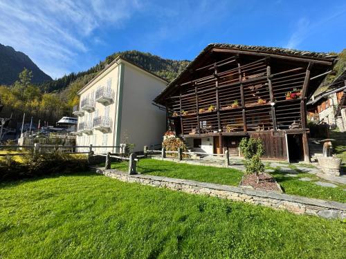 a large building with a grass yard in front of it at Stilish wooden chalet fully renovated near the lifts in Alagna Valsesia