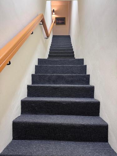 a staircase with grey carpeting and a stair case at Sunshine Hotel in Bahau
