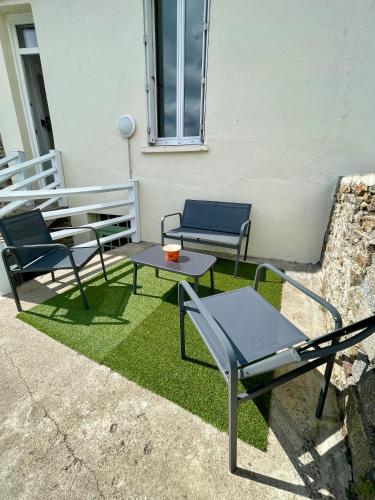 a patio with two chairs and a table and chairs at T1 bis à la décoration soignée in Lamballe Armor