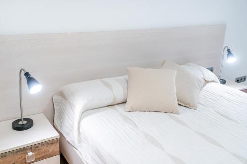 a white bed with two pillows on it in a bedroom at La Bicicleta in Valderrobres