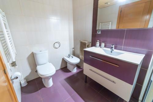 a white bathroom with a toilet and a sink at La Bicicleta in Valderrobres