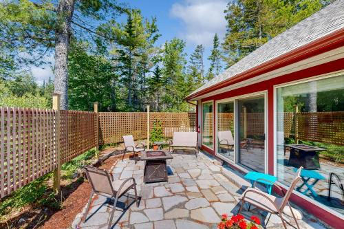 a patio with chairs and a wooden fence at Maine's Nature Getaway in Hancock