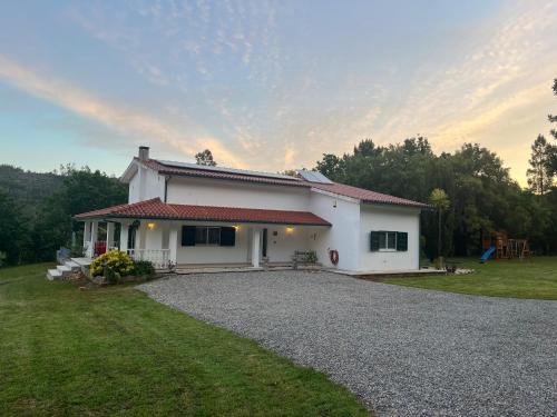 a small white house with a gravel driveway at Casa Toupeira in Folques