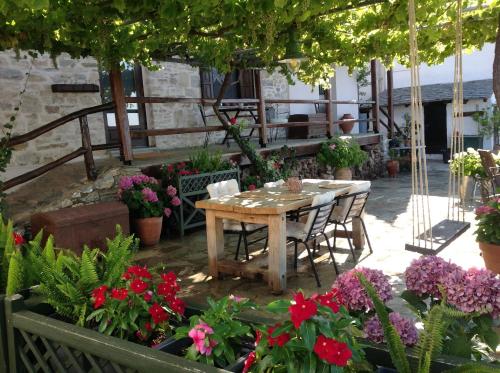 a table and chairs in a garden with flowers at Μακρινίτσα Αλώνια in Makrinítsa