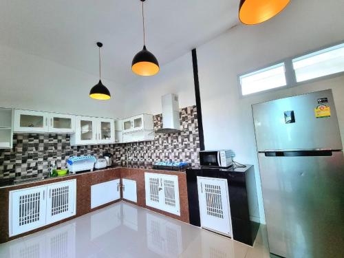 a kitchen with a stainless steel refrigerator and cabinets at Heartbeat Fall in Love in Sattahip