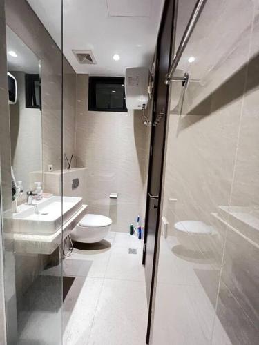 a bathroom with a toilet and a sink and a shower at Chic n Spacey 3BR apartment at the Rosebay in Surabaya