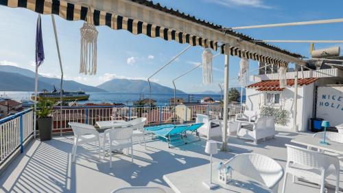 a patio with white chairs and a view of the water at Melissani hotel in Sami