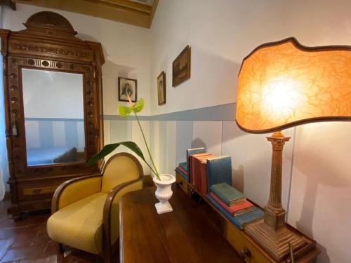 a living room with a table with a lamp and a chair at Residenza D'Epoca San Lorenzo Tre in Todi