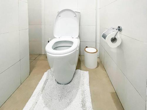 アクラにあるSafari Luxury Apartmentの白いラグが敷かれたトイレ付きのバスルーム
