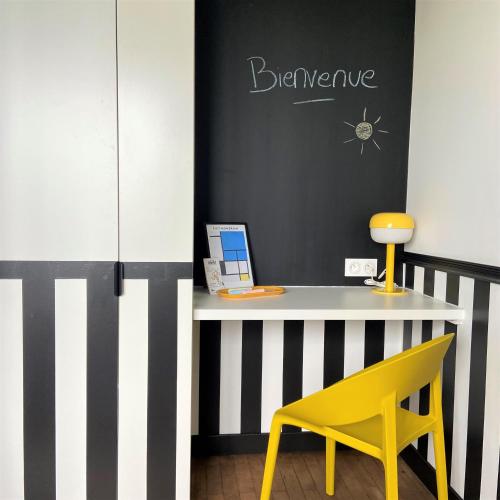 une chaise jaune à côté d'un bureau avec un ordinateur portable dans l'établissement Bord Erdre - Proche Gare et transports, à Nantes