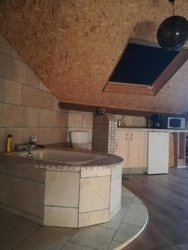 - une cuisine avec une grande baignoire au milieu d'une pièce dans l'établissement Le sas des familles, à Limoges