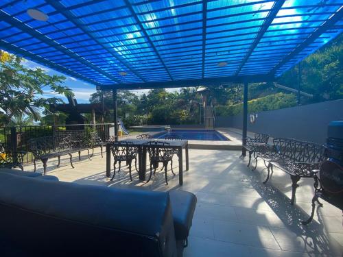 a patio with tables and chairs and a pool at Finca La Samara in El Higuerón