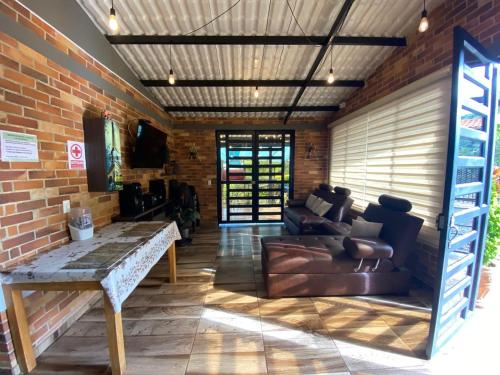 a living room with a couch and a brick wall at Finca La Samara in El Higuerón