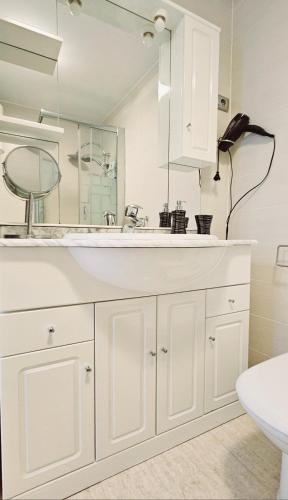 a white bathroom with a sink and a mirror at Perla del Paraiso in Playa Paraiso