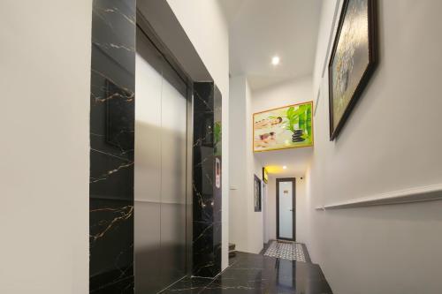 a hallway with black tile and white walls and a black tile floor at Dream Premium Hotel & Spa in Hanoi