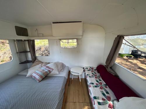 une petite pièce avec un lit et une table dans l'établissement Caravane amy on the beach, à Lucciana