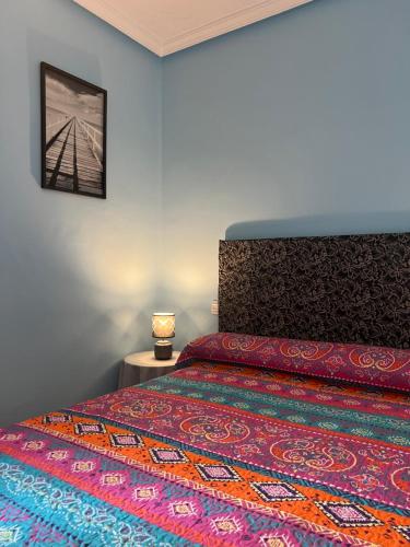 a bedroom with a bed with a colorful bedspread at Piso Los Jardines in Peñaranda de Bracamonte