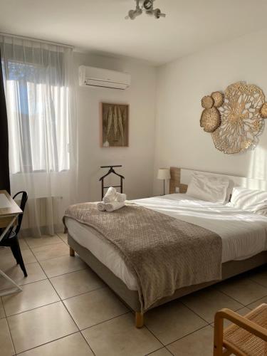 a bedroom with a bed and a table and a chandelier at H&ocirc;tel Pyr&egrave;ne in Foix