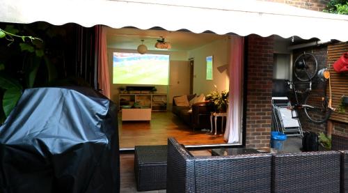 a living room with a couch and a television at 3-Bed House with Amazing Garden in London