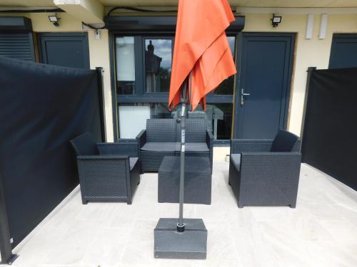 a group of chairs and an orange flag on a pole at Tsara Home in Le Trait