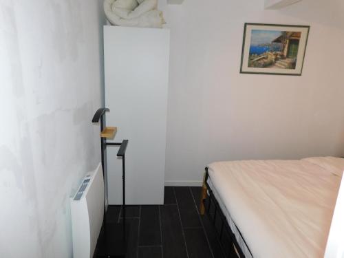 a small room with a bed and a picture on the wall at Tsara Home in Le Trait