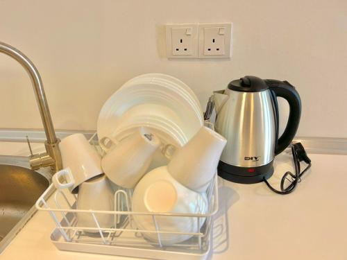 a basket of dishes and a coffee pot on a kitchen counter at imperium residence kuantan in Kuantan