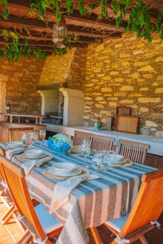a table with plates and wine glasses on it at Just Like Home - Casa da Telheira in Caminha