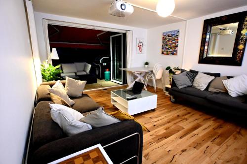 a living room with two couches and a table at 3-Bed House with Amazing Garden in London