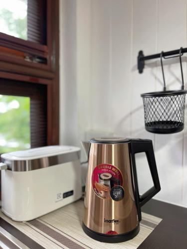 a coffee pot sitting on a counter next to a toaster at Anna River Home A2 in Ban Khlong Si