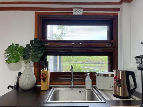a kitchen sink with a window above a kitchen counter at Anna River Home A2 in Ban Khlong Si