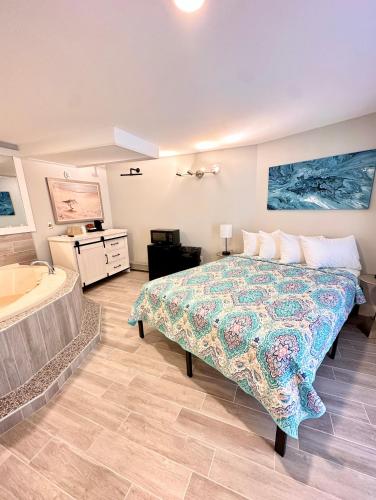 a bedroom with a bed and a sink and a tub at Abellona Inn & Suites in Old Orchard Beach