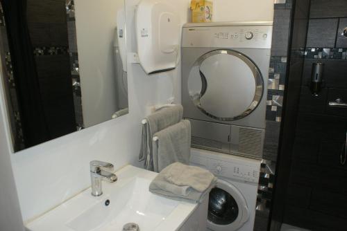 une salle de bain avec un lavabo et une machine à laver dans l'établissement gites Obeaurepere, à Boulogne-sur-Mer
