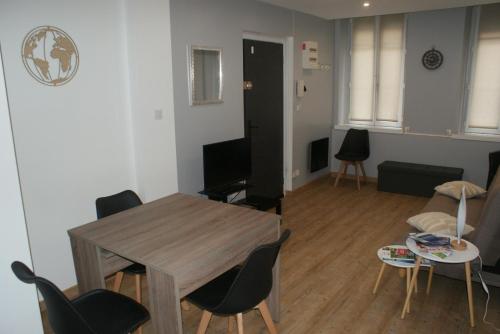 un salon avec une table, des chaises et un canapé dans l'établissement gites Obeaurepere, à Boulogne-sur-Mer