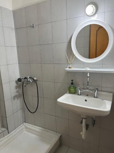 a bathroom with a sink and a shower with a mirror at Hotel Katia in Paralia Katerinis
