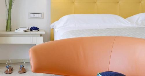 an orange chair in a bedroom with a bed at Hotel Villa Blu Capri in Anacapri