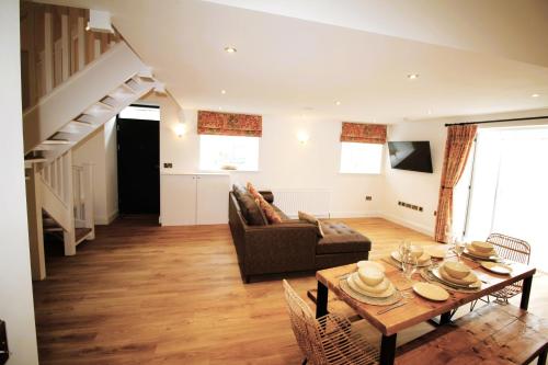 a living room with a table and a couch at Sleeps 4 - Town Centre - Very High End Renovation - Private Garden - Close to Train Station - Fast Wifi in Berwick-Upon-Tweed