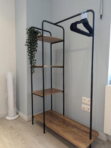 a black shelf with wooden shelves in a room at Les Bêtises, Duplex Hyper-centre in Cambrai