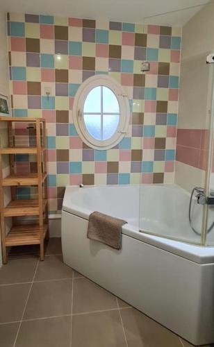 une salle de bain avec une baignoire et une fenêtre dans l'établissement Proche Disneyland Paris, magnifique villa, à Bussy-Saint-Georges
