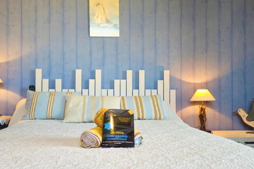 a bed with a white headboard with a book on it at L'Oustal 3 chambres avec grand jardin parking gratuit in Bram