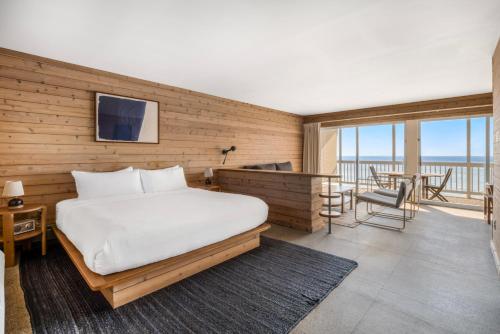 a bedroom with a bed and a balcony with a table at Sound View Greenport in Greenport