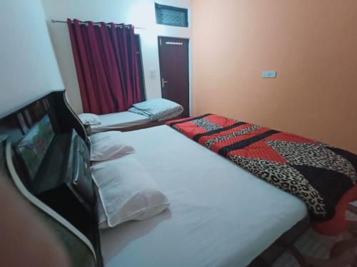 a small bedroom with a bed and a curtain at Hotel Jagdamba & Restaurant in Gupta Kāshi