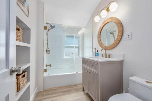 a white bathroom with a sink and a mirror at 232 Wood Road South Yarmouth - Cape State of Mind in South Yarmouth